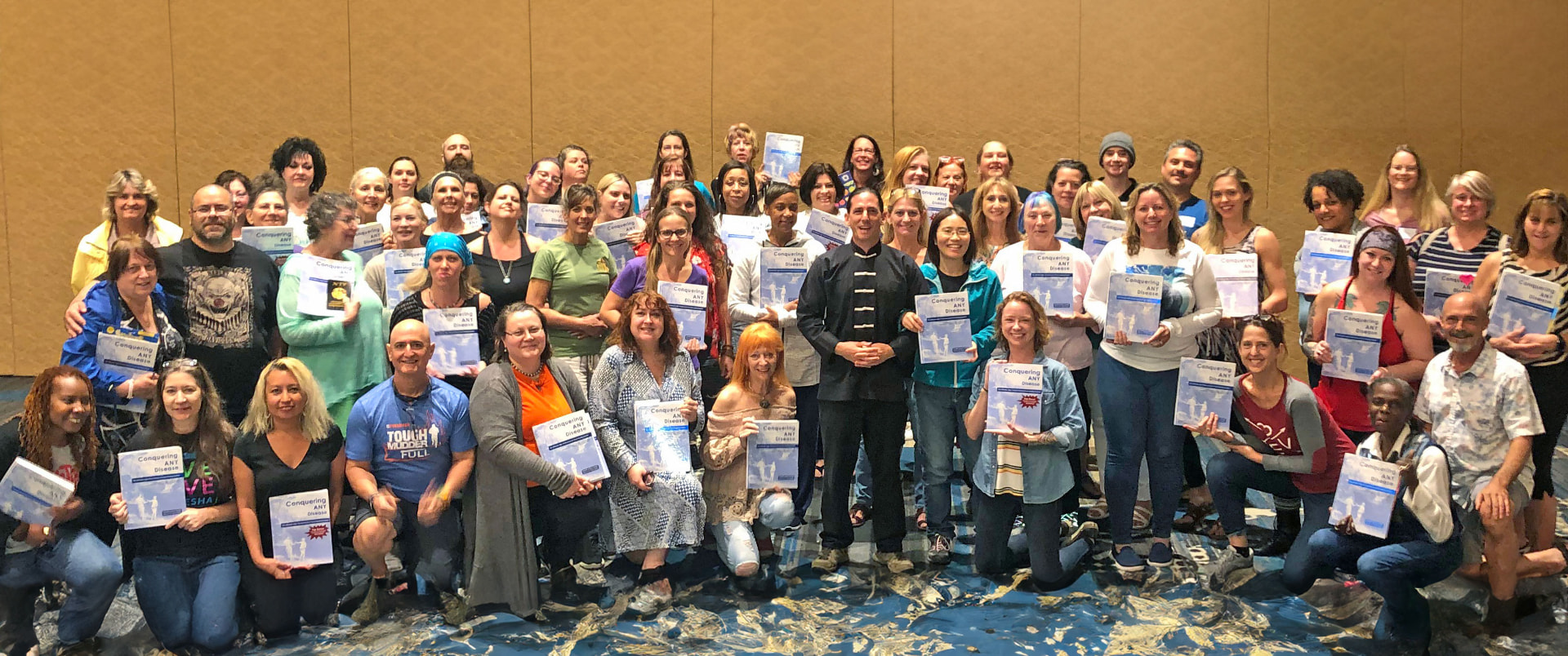 Food Healing Certification graduates holding Conquering ANY Disease books